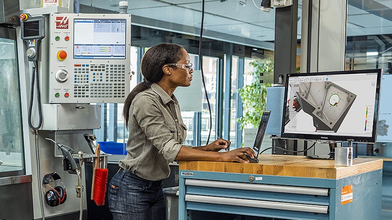 Woman working at a computer in a fabrication studio 